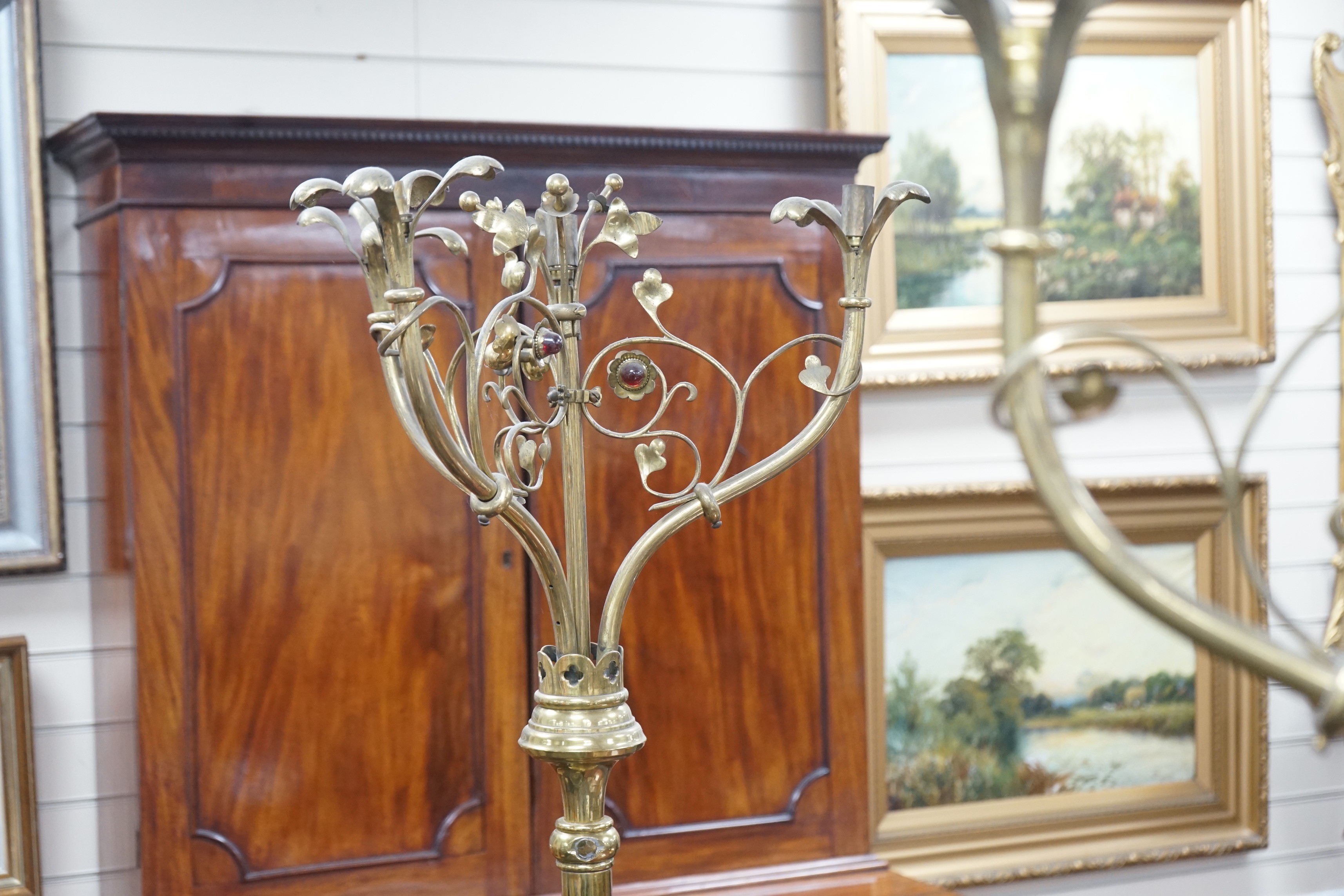 A pair of Victorian Gothic brass ecclesiastical three branch floor lamps, converted to electricity, height 195cm